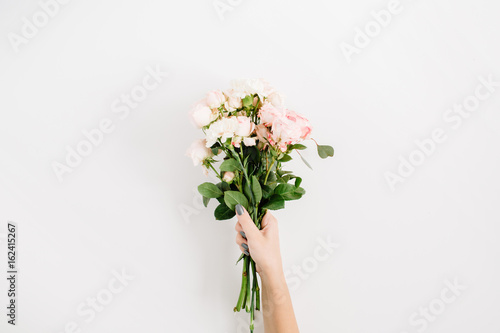Beautiful pink rose flower bouquet in girls hand isolated on white background. Flat lay, top view. Floral composition © Floral Deco