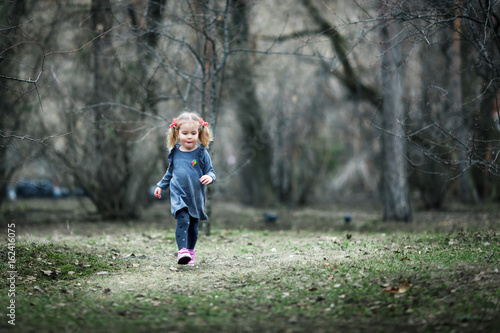 Little beautiful girl walking in a summer park