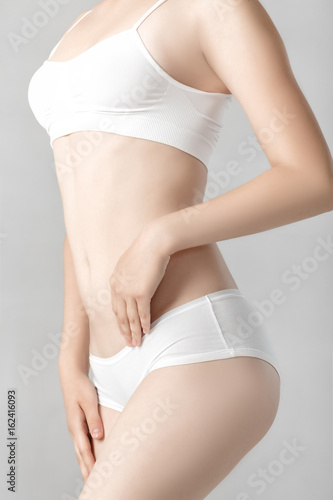 Perfect sports body of woman in white lingerie. Slim female shape