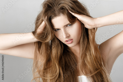 portrait of upset woman with long hair. hopelessness or headache