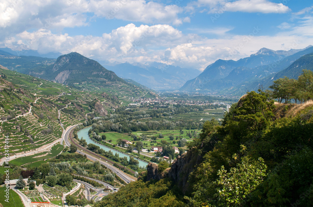 Valley with river and fields and mountains in the background - Sion, Switzerland