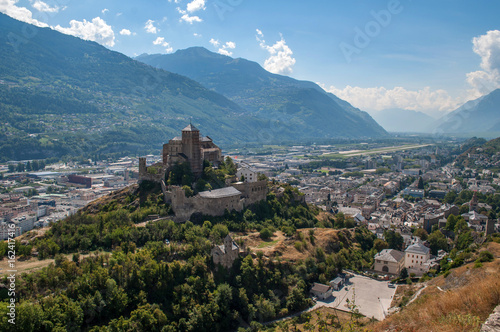 Old stone castle and small town in the middle of high mountains (Sion, Switzerland)