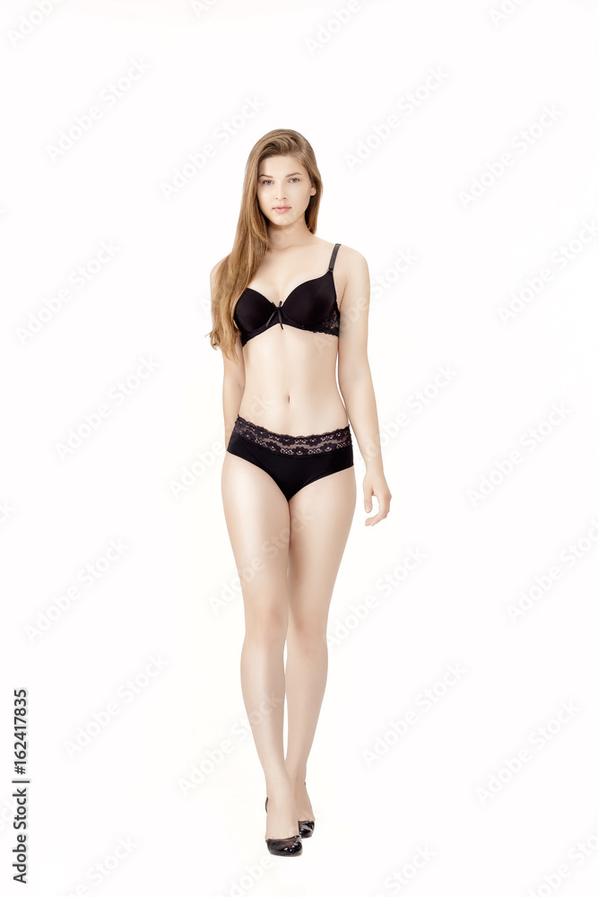 Young slender woman in black lingerie isolated on white background Young slender woman in black lingerie isolated on white background