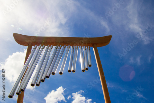 Fotografie Wind musical chimes on the background of blue cloudy summer sky.