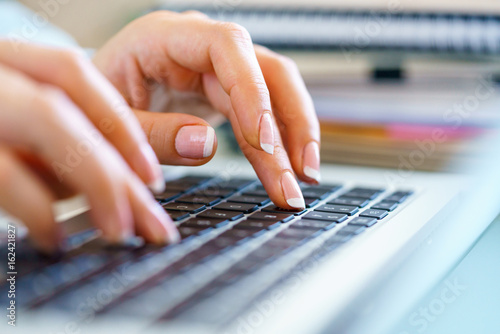 Closeup female hands on laptop keyboard