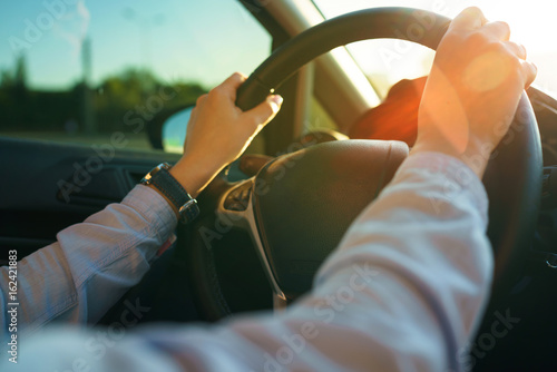 Close-up of female hands on the steering wheel