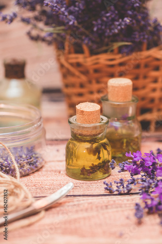 Fototapeta Naklejka Na Ścianę i Meble -  Lavender oil with fresh flowers on wooden background.