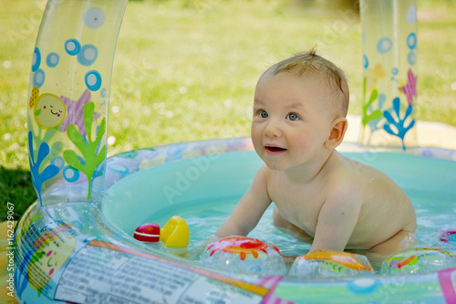 baby having fun in the garden swimming pool