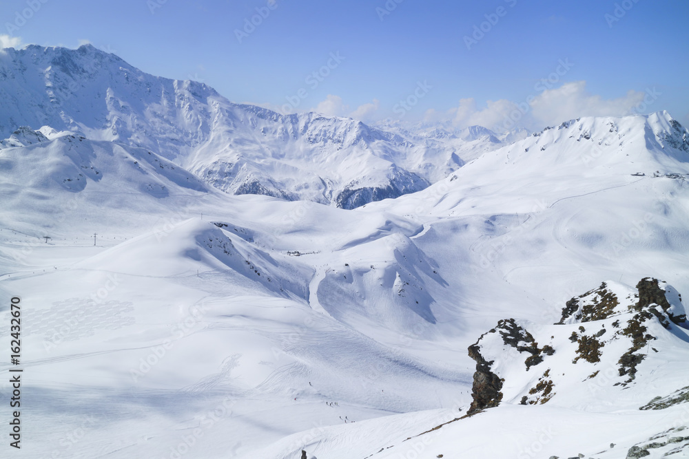 Alpine snowy peaks landscape with skiing slopes and lifts in Paradiski ski area, Alps, France