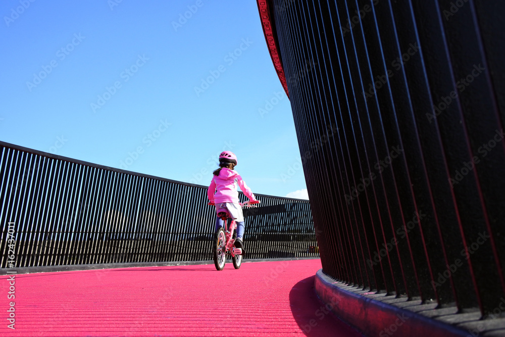 Fototapeta premium Girl rides bike on pink cycleway in Auckland