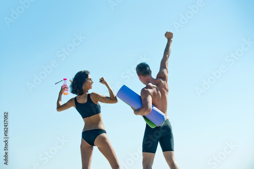 happy man with muscular body, dumbbell, girl, couple in love