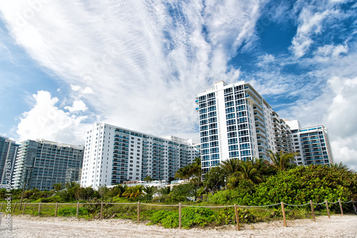 apartment buildings along sandy beach with palm trees © be free