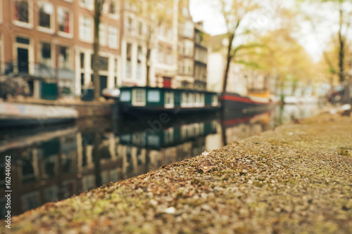 Canal and houseboat in Amsterdam. Blurred background. May 2017.