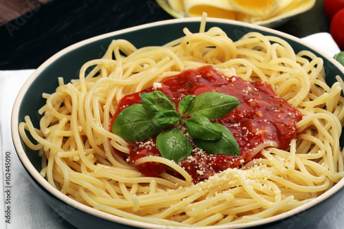 Plate of delicious spaghetti Bolognaise or Bolognese with savory minced beef and tomato sauce garnished with parmesan cheese and basil