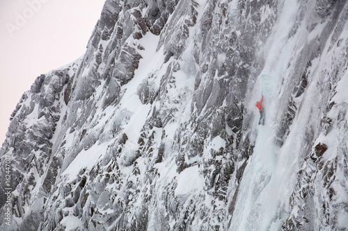 Climber soloing during blizzard on steep ice climb