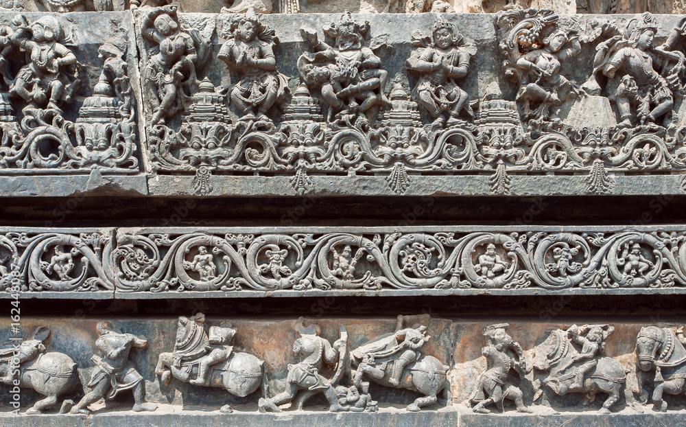 Indian architecture background. Dancing people ruined on traditional style relief, with patterns inside the temple in India.