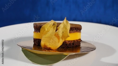 Cake is decorated fresh Physalis fruit. Sweet dessert on dark blue background photo