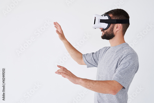 Bearded male playing video game and gesturing with his hands like catching something