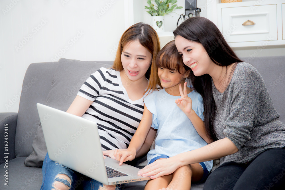 Mother, Aunt and kid having time together lerning with using laptop at home on couch, family concept. Mother, Aunt and kid having time together lerning with using laptop at home on couch, family concept.