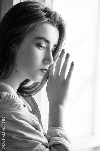 sensual sad female portrait with near window, monochrome