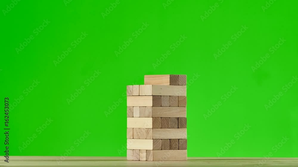 Wooden puzzles jenga gather in tall tower. Stop motion, green screen