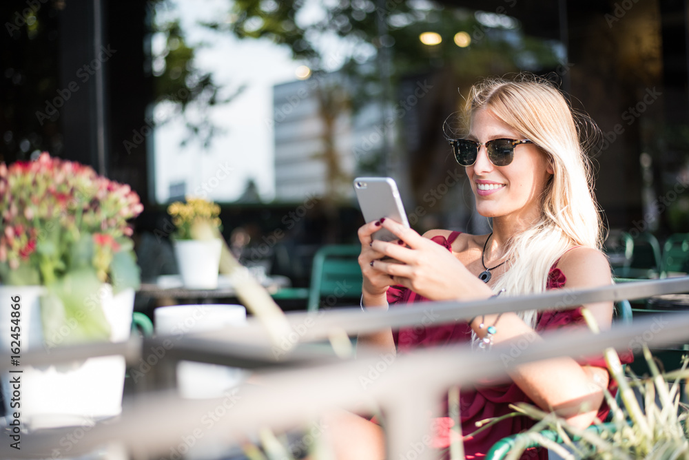 custom made wallpaper toronto digitalHappy blonde beautiful woman using a mobile phone drinking a cup of coffee in a terrace