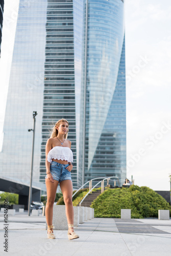 beautiful blonde woman wearing short jeans walking on the street