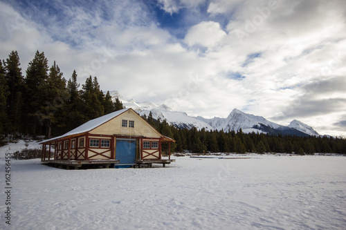 Empty hut and boat dock on winter frozen lake in high mountains, maligne lake, jasper nation park, Canada © Jan