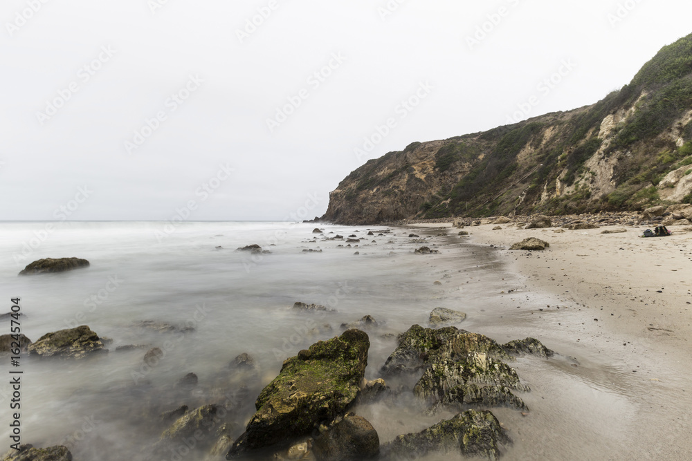 Dume Cove with motion blur waves and clouds in Malibu, California