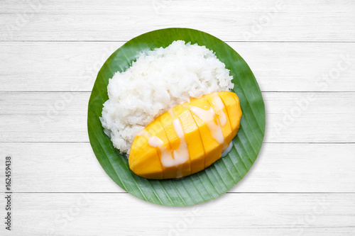 dessert sweet sticky rice with mango coconut milk on white wooden.