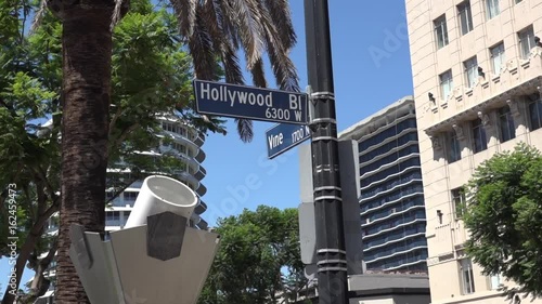 Zoom out shot of street sign at Hollywood and Vine
