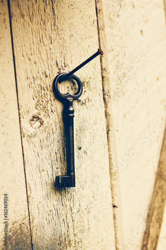 Old key hanging on old wooden barn wall © AnnMarie