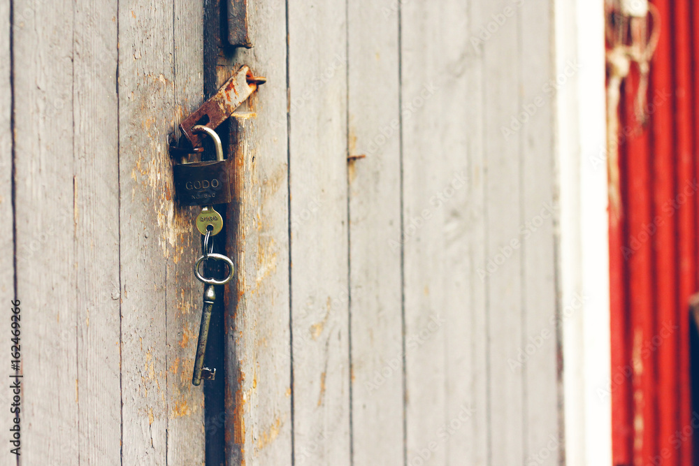 Old rusty padlock with keys on wooden barn door Old rusty padlock with keys on wooden barn door