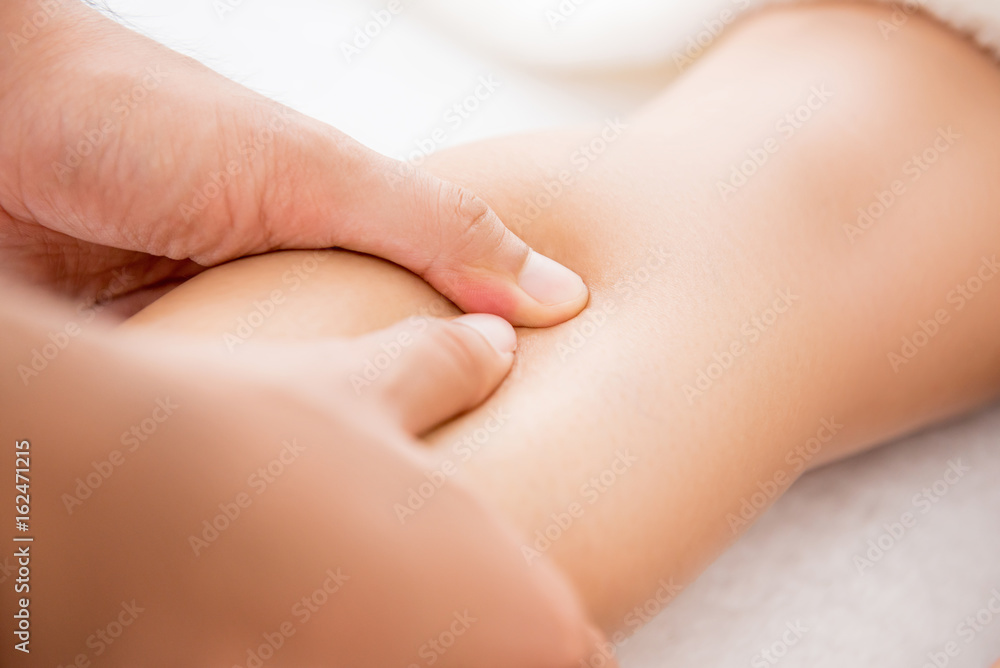 Hands of male therapist giving leg massage to a woman in spa Hands of male therapist giving leg massage to a woman in spa