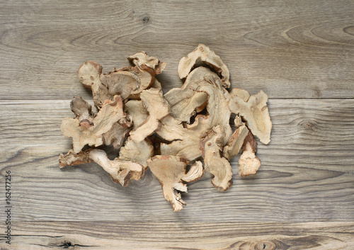 dry galangal ginger on wood background
