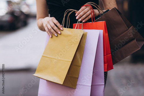 Fashionably dressed woman with colored shopping bags, shopping concept
