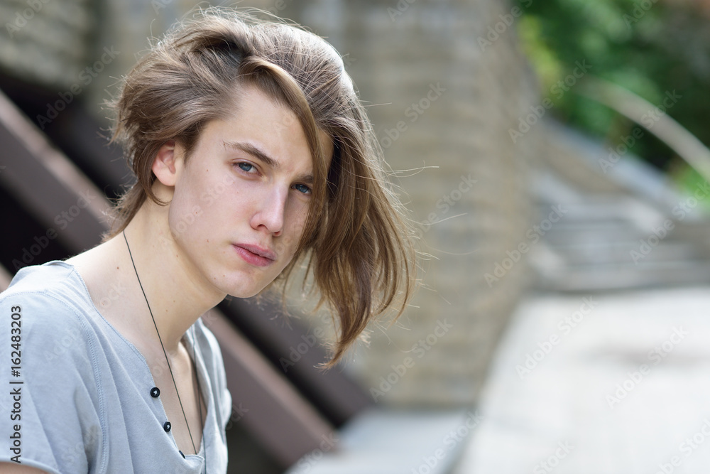 Portrait of young handsome man, city outdoor. Attractive trendy fashion 18  years old teen boy posing outside Stock Photo