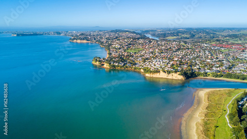 Aerial view on sunny beach with residential suburb on the background. Auckland  New Zealand.