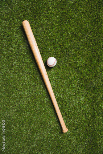 top view of baseball bat and ball on grass field