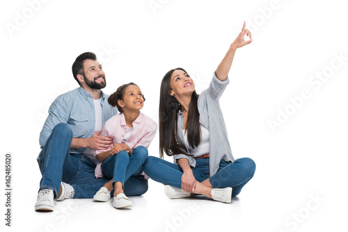 woman pointing away, family sitting near by and looking away isolated on white