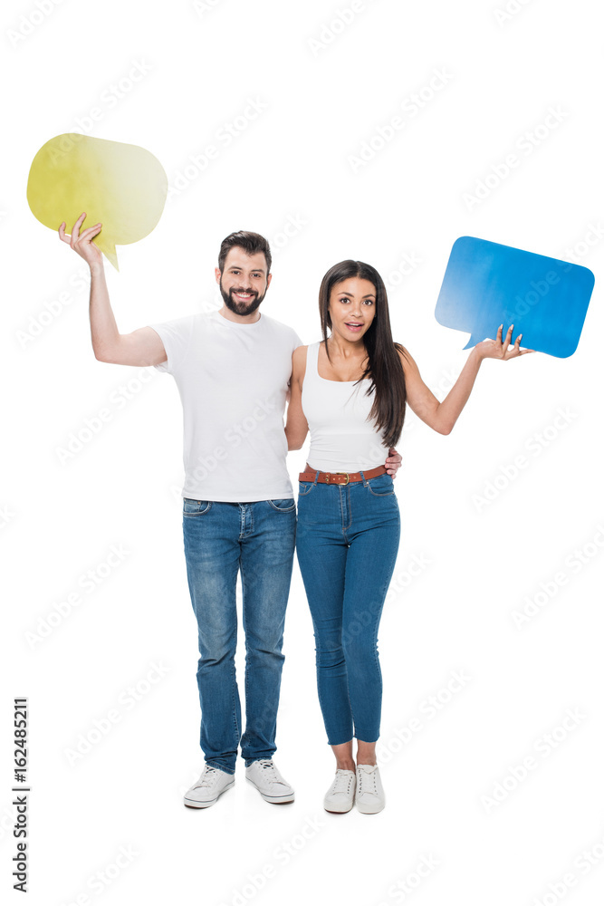 Smiling couple holding blank speech bubbles isolated on white Smiling couple holding blank speech bubbles isolated on white