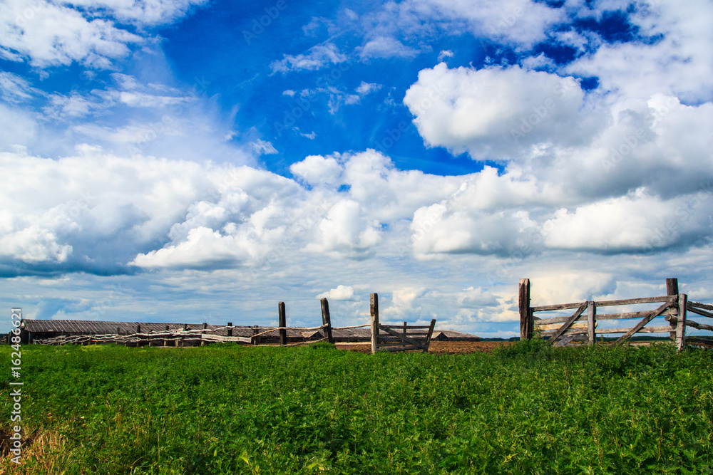 Picture of a fence of logs in a village with a landscape Picture of a fence of logs in a village with a landscape