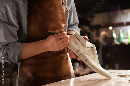 Close up of a male shoemaker drawing design photo