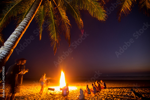 Obraz na płótnie Surfers gather around a campfire on the beach in Santa Teresa, Costa Rica w salonie