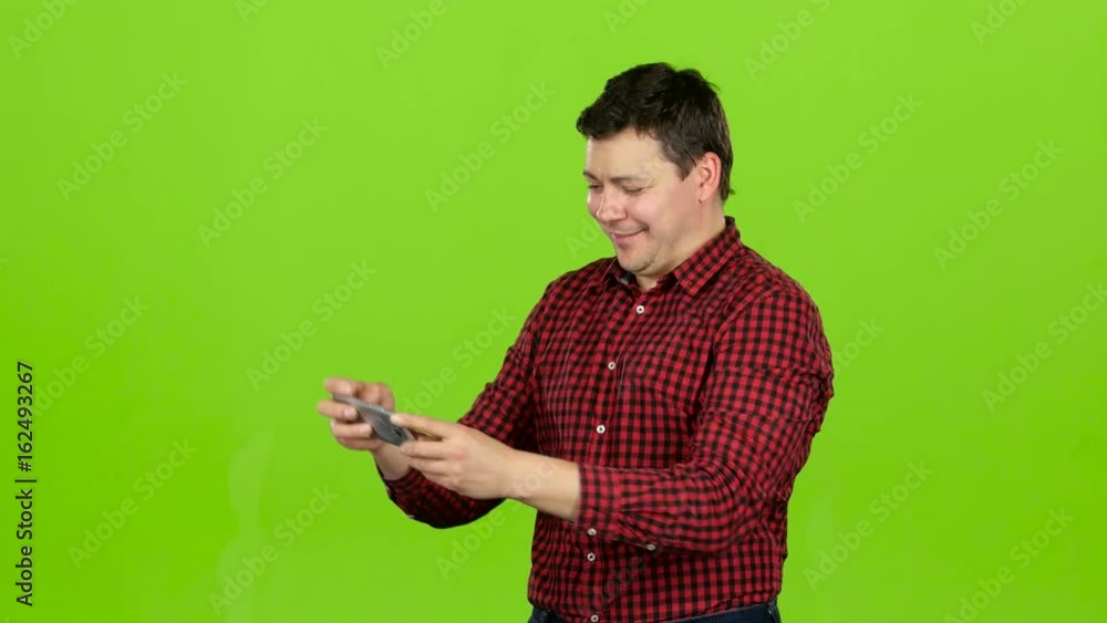 Man takes pictures on the phone, he is happy and cheerful. Green screen Man takes pictures on the phone, he is happy and cheerful. Green screen