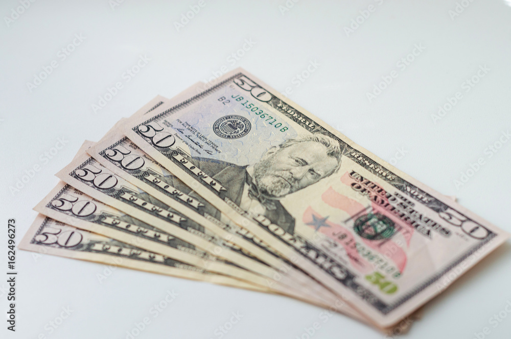 A stack of fifty dollar bills fanned out on a white background A stack of fifty dollar bills fanned out on a white background