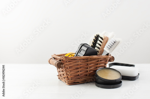 Brushes and Shoe Polish in a basket on white
