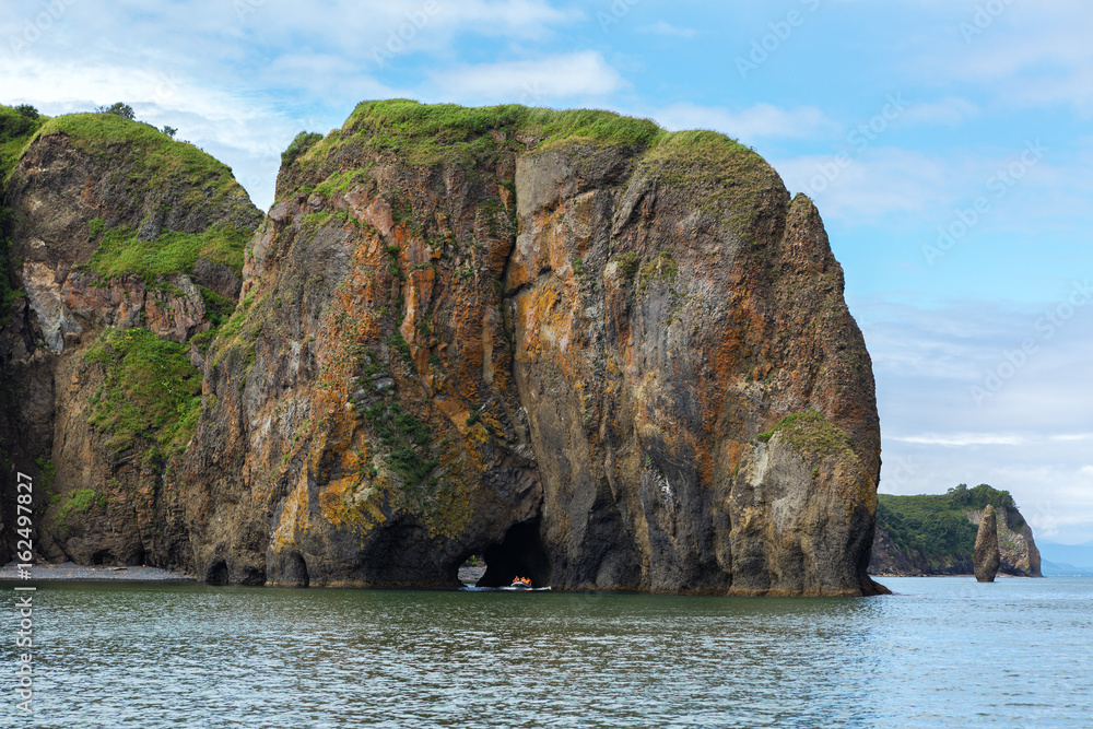 Rocks with caves and grottoes in Avacha Bay of Pacific Ocean. The coast of Kamchatka.