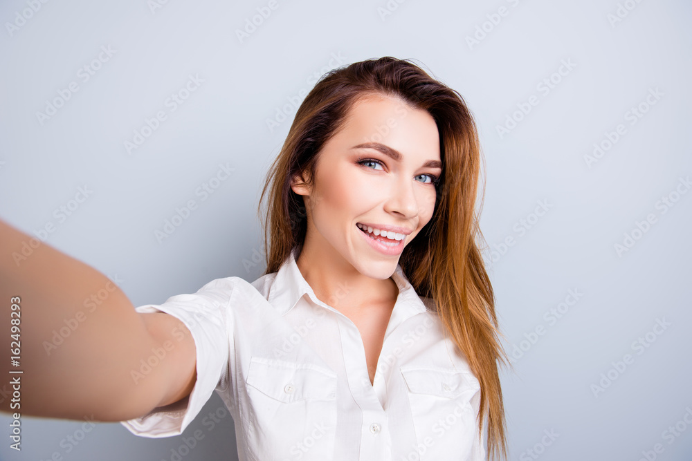 Selfie mania! So hot and pretty! Attractive young lady is making a selfie on the camera, flirty and playful. In casual wear, on pure light background Selfie mania! So hot and pretty! Attractive young lady is making a selfie on the camera, flirty and playful. In casual wear, on pure light background