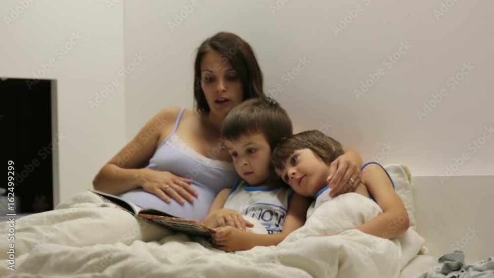 Pregnant mum, reading bedtime story for her sons Pregnant mum, reading bedtime story for her sons
